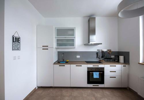 a kitchen with white cabinets and a stove top oven at Krona Apartments in Bovec
