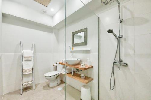 a bathroom with a shower and a toilet and a sink at Maresía Canteras Urban Hotel in Las Palmas de Gran Canaria