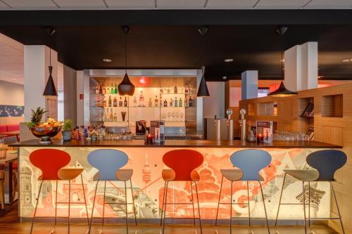 a bar in a restaurant with stools at ibis München City Süd in Munich