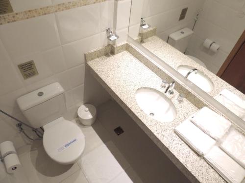 a bathroom with a white toilet and a sink at Hotel Hetropolis in São Bernardo do Campo