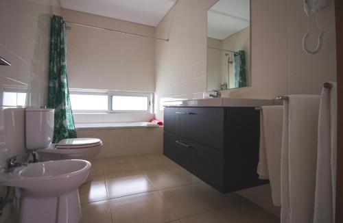 a bathroom with a sink and a toilet and a tub at Quinta De Santana in Rabo de Peixe
