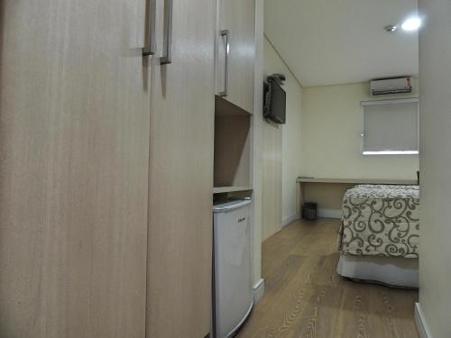 a small room with a refrigerator and a bed at Hotel Hetropolis in São Bernardo do Campo