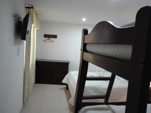a bedroom with a bunk bed with a ladder and a room at Hotel Sipa in Duitama