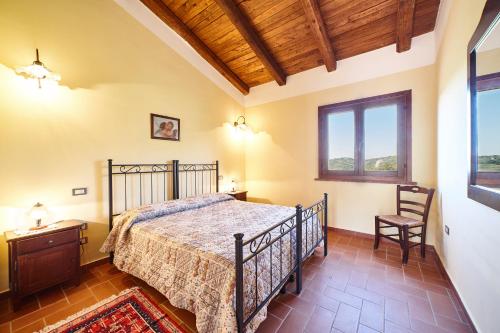 um quarto com uma cama e um tecto de madeira em Agriturismo i Moresani em Casal Velino