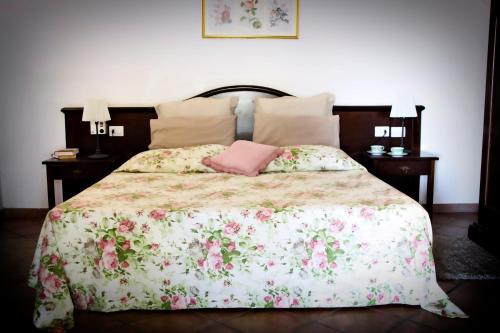 a bedroom with a bed with a pink pillow on it at Le Case Del Merlo Turismo Rurale in Milo