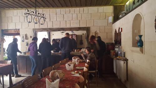 a group of people standing in a restaurant with tables at Jerveni Cave Hotel in Mustafapaşa