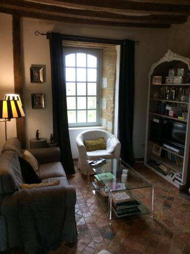 a living room with two couches and a window at La Moulinière, jolie longère du XVIIè 25, chemin de la Source in La Jaille-Yvon