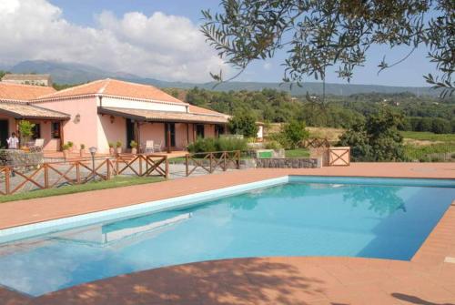 a swimming pool in front of a house at Agriturismo Le Case Del Merlo in Milo