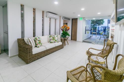 a living room with a couch and two chairs at Hotel Casa Vallecaucana in Cali