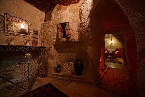 Cette chambre est dotée d'un mur en pierre avec deux vases. dans l'établissement Jerveni Cave Hotel, à Mustafapaşa