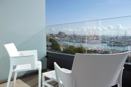a balcony with white chairs and a view of a harbor at Hotel Costa Azul in Palma de Mallorca