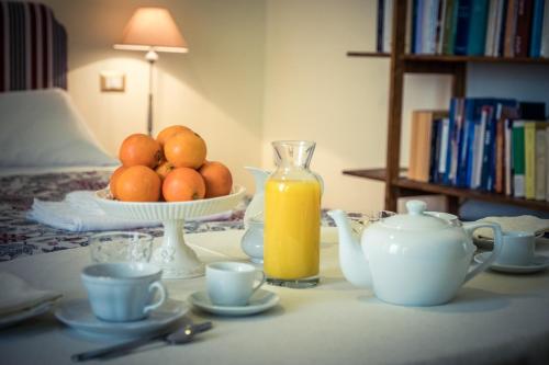 a table with a bowl of oranges and a bottle of orange juice at Palazzo Bernardini Suites in Lecce