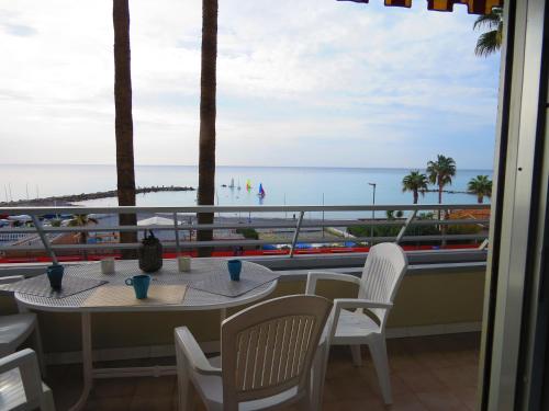 a table and chairs on a balcony with a view of the beach at Casa Lea in Ventimiglia