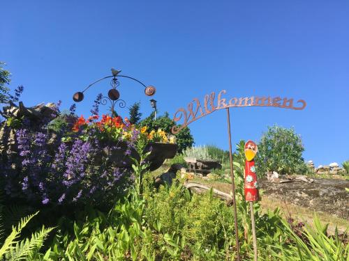 a garden with flowers and a sign in the background at Gästehaus Huber in Arbesbach