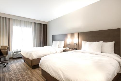 a hotel room with two beds and a window at Country Inn & Suites by Radisson, Smyrna - Atlanta Northwest in Smyrna