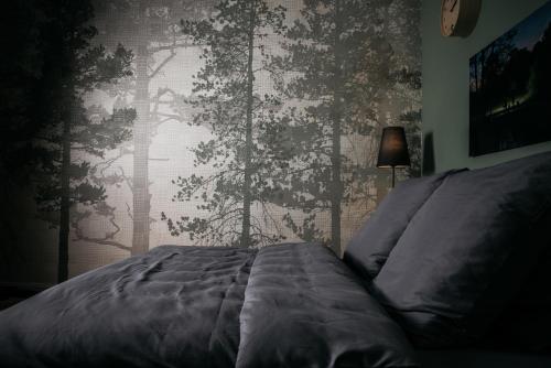 um quarto com uma cama e uma parede com árvores em Urbn Dreams em Berlim