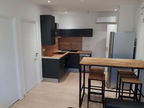 eine Küche mit einem Holztisch und einem Kühlschrank in der Unterkunft Nice Apartment in Menton French Riviera in Menton