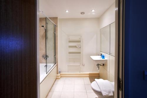a bathroom with a shower and a toilet and a sink at The Paramount, Swindon in Swindon