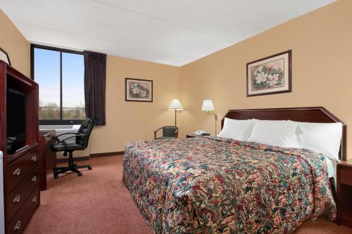 a hotel room with a bed and a desk at Days Inn by Wyndham Hagerstown I-70 in Hagerstown