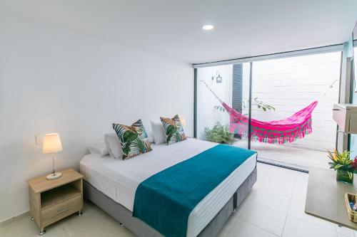 a bedroom with a bed and a large window at Hotel Casa Vallecaucana in Cali