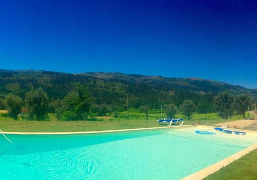 a large swimming pool with a mountain in the background at Quinta da Aranha in Arcos de Valdevez