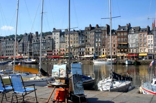 
a harbor filled with lots of boats on a sunny day at La Maison d'Eugène Appart'Hôtel - Centre Historique in Honfleur
