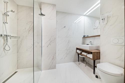 a bathroom with a shower and a toilet and a sink at Hotel Garden Hill in Velika Gorica