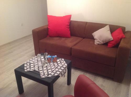 a living room with a brown couch and a table at Au mas des graviers in Salavas
