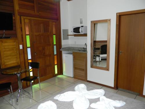 een kamer met een keuken met een tafel en een spiegel bij Recanto dos Kerr in Monte Verde