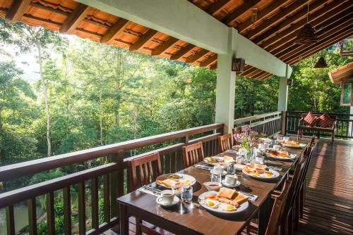 a table on a balcony with food on it at Rest Pause Rainforest Retreat in Bentong