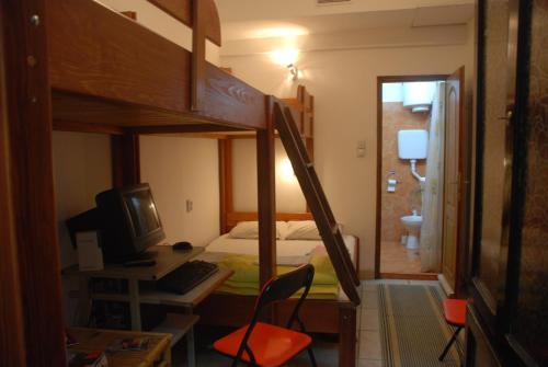 1 dormitorio con litera y escritorio con ordenador en Tash Inn Hostel, en Belgrado