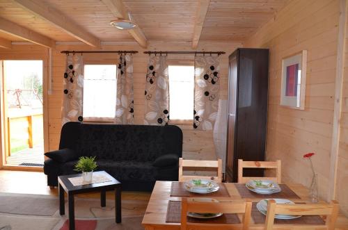 uma sala de estar com um sofá e uma mesa em Domki Letniskowe U Cichego em Jezierzany