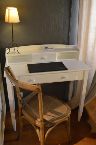escritorio blanco con silla y lámpara en La Chamberte, en Villeneuve-lès-Béziers