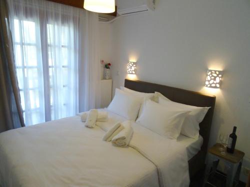 a bedroom with a white bed with towels on it at Wood and Stone Villa in Sani Beach