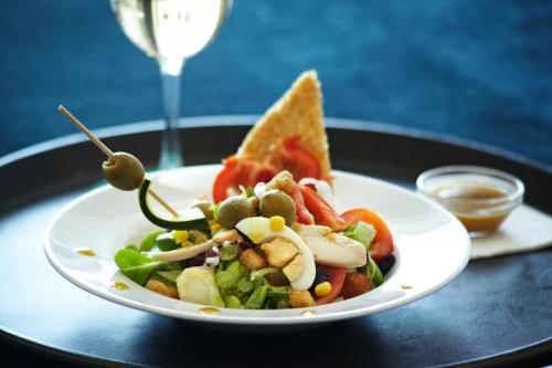 a plate with a salad and a sandwich on a table at Hotel Costa Azul in Palma de Mallorca