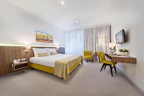 um quarto de hotel com uma cama e uma secretária em Hotel Garden Hill em Velika Gorica