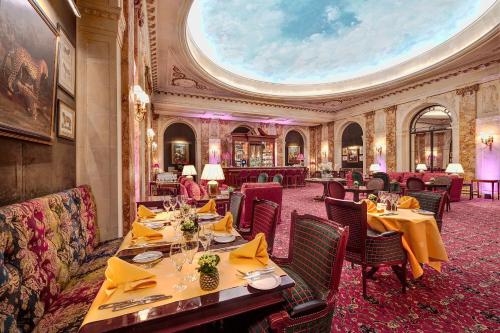 a restaurant with tables and chairs and a domed ceiling at Hotel Le Plaza Brussels in Brussels