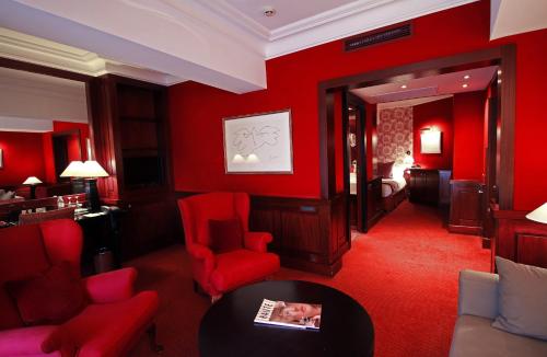 a red living room with red chairs and a table at Grand Hotel de l'Opera - BW Premier Collection in Toulouse