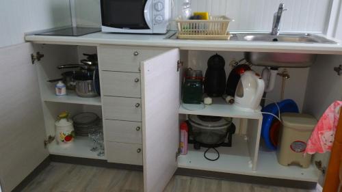 a kitchen counter with a sink and a microwave at Astrofegia Apartments Near The Sea in Ayia Marina