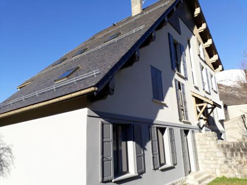 a house with solar panels on the roof at Chalet du Doumet - Appart LUZ centre - parking et garage individuel ferme - draps et serviettes inclus in Luz-Saint-Sauveur
