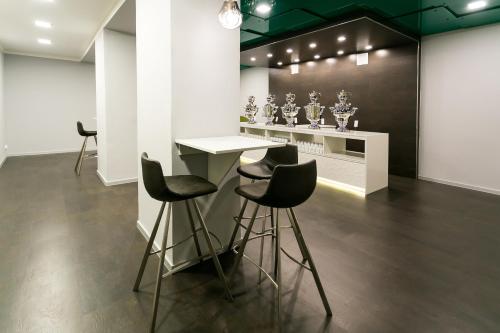 a room with a table and four stools in it at ASTORIA Hotel & Medical Spa in Karlovy Vary
