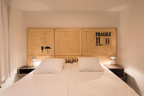 a bedroom with a white bedspread and white pillows at B's Strandappartementen in Domburg