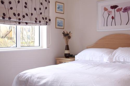 una camera con un letto bianco e una finestra di Achill a Bushmills