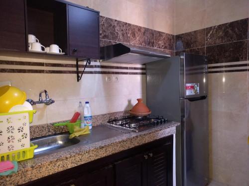 uma cozinha com geladeira de aço inoxidável e pia em Appartement Marrakech em Marraquexe