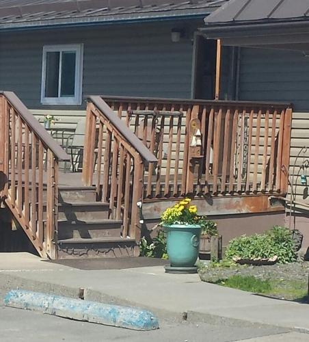 a wooden staircase in a house with a pot of flowers at Beluga Lake Lodge in Homer