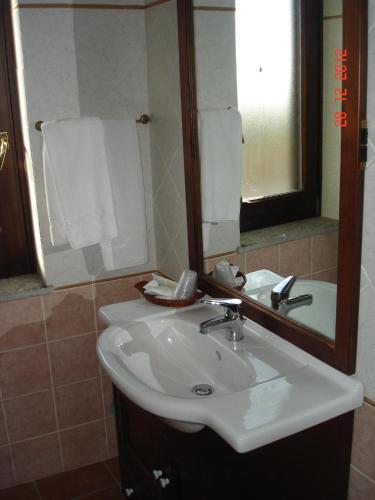 a bathroom with a sink and a mirror and towels at Agriturismo Casale Di Gricciano in Cerveteri