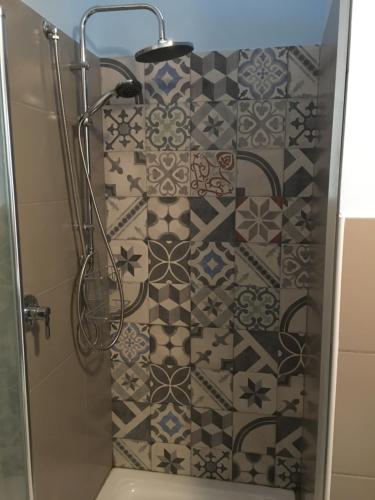 a bathroom with a shower with a tiled wall at Torrearsa 17 in Trapani