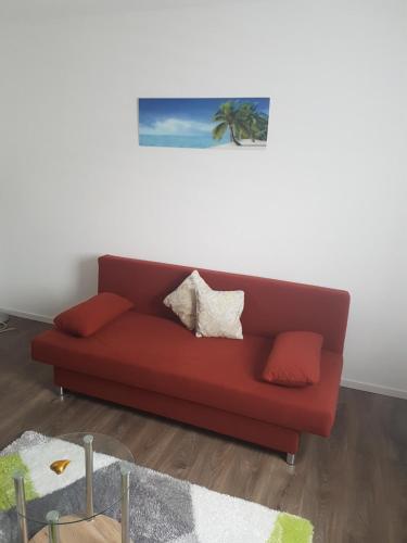 ein rotes Sofa im Wohnzimmer in der Unterkunft Schöne, private Wohnungen in Aalen