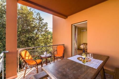porche con mesa de madera y sillas en el balcón en Casa Giovanni, en Cala Gonone