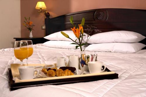 a tray of food and drinks on a bed at Vytina Mountain View Hotel in Vytina